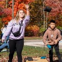 Two kids playing cornhole.